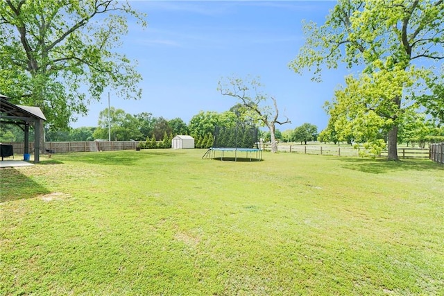 view of yard with a trampoline, a storage unit, an outdoor structure, a patio, and a gazebo