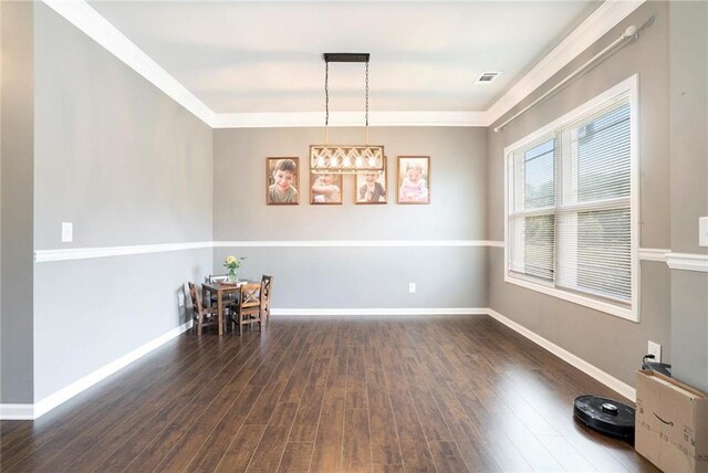 dining area featuring wood finished floors, baseboards, and ornamental molding