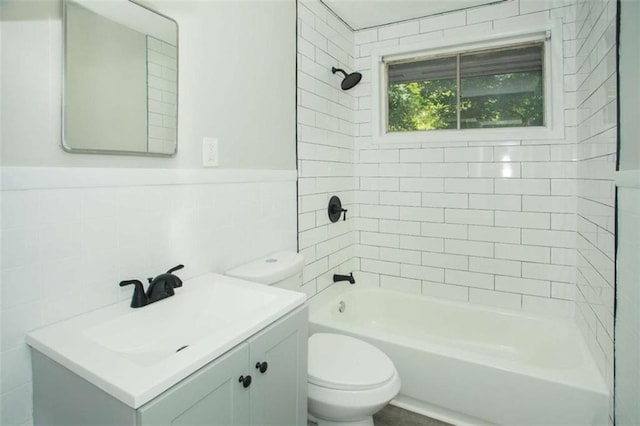 full bathroom featuring toilet, tile walls, wainscoting, shower / bath combination, and vanity