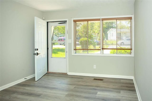 doorway with visible vents, baseboards, and wood finished floors