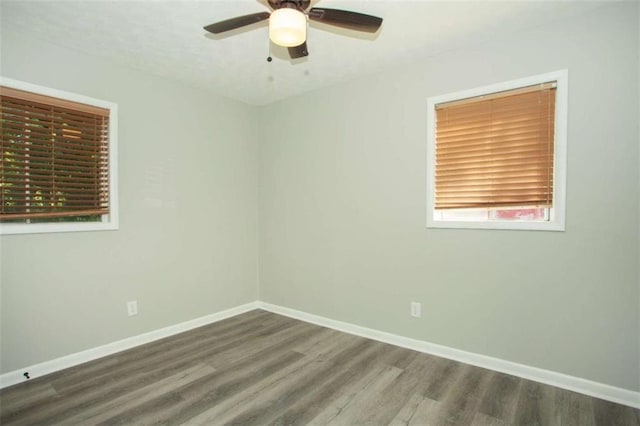 empty room with a ceiling fan, baseboards, and wood finished floors