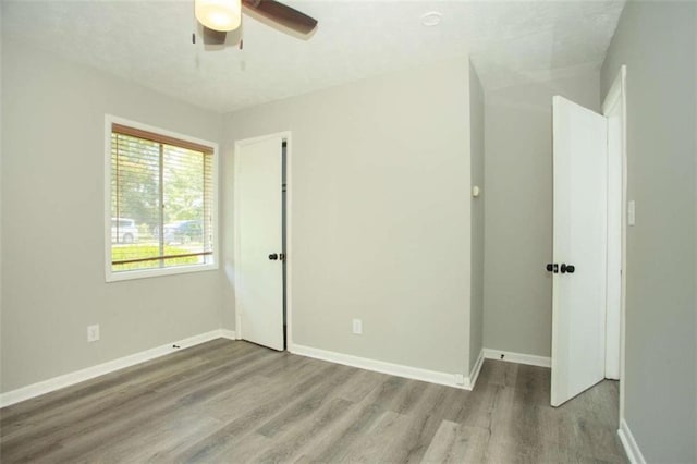 unfurnished bedroom featuring ceiling fan, baseboards, and wood finished floors