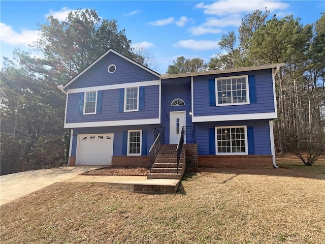 split foyer home with driveway, an attached garage, and brick siding