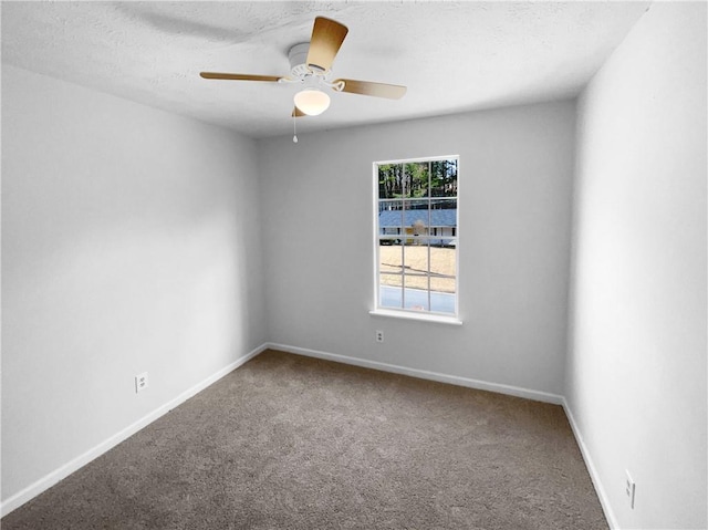 carpeted spare room featuring a ceiling fan, a textured ceiling, and baseboards