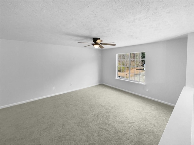 unfurnished room featuring carpet floors, ceiling fan, a textured ceiling, and baseboards