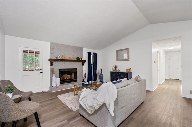 4771 N Springs Rd NW, Kennesaw, GA 30144 - living room featuring wood finished floors, a stone fireplace, lofted ceiling, and baseboards