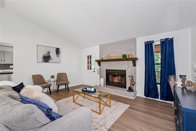 4771 N Springs Rd NW, Kennesaw, GA 30144 - living area with vaulted ceiling, a stone fireplace, wood finished floors, and baseboards