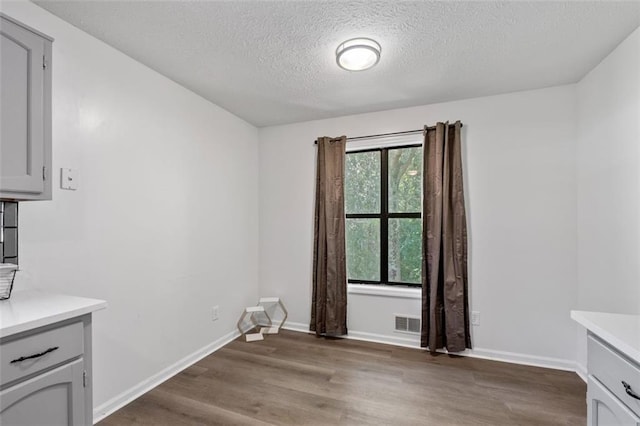 4771 N Springs Rd NW, Kennesaw, GA 30144 - unfurnished dining area featuring light wood-type flooring, a textured ceiling, and baseboards
