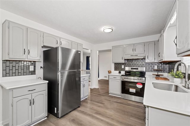 4771 N Springs Rd NW, Kennesaw, GA 30144 - kitchen featuring stainless steel appliances, backsplash, a sink, light countertops, and light wood-style floors