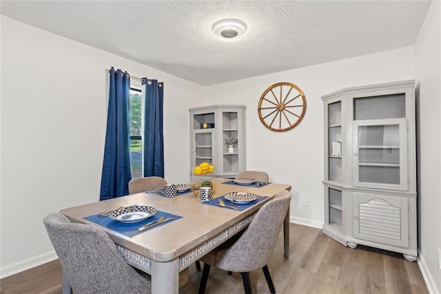 4771 N Springs Rd NW, Kennesaw, GA 30144 - dining area featuring a textured ceiling, wood finished floors, and baseboards