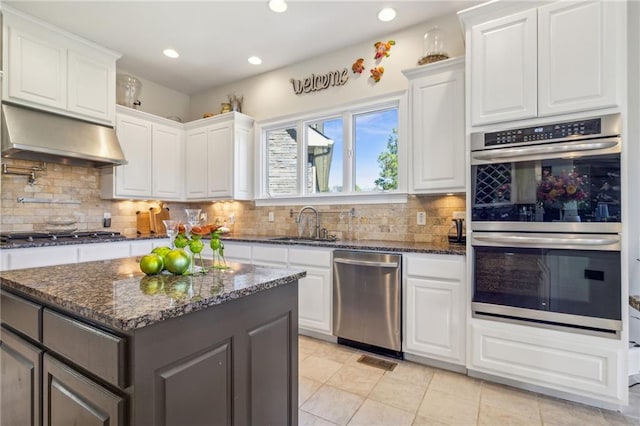 kitchen featuring white cabinetry, appliances with stainless steel finishes, backsplash, and a center island