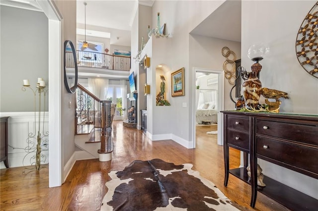 entrance foyer featuring a towering ceiling, light hardwood / wood-style flooring, and ceiling fan