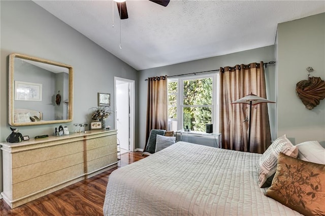bedroom featuring a ceiling fan, a textured ceiling, lofted ceiling, and wood finished floors