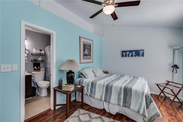 bedroom featuring a ceiling fan, wood finished floors, and connected bathroom