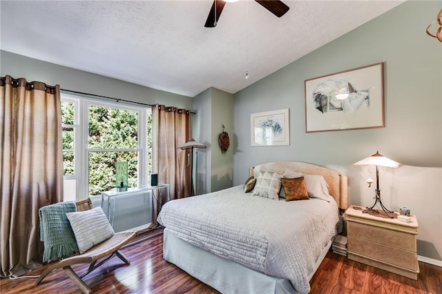 bedroom featuring ceiling fan, a textured ceiling, wood finished floors, baseboards, and lofted ceiling