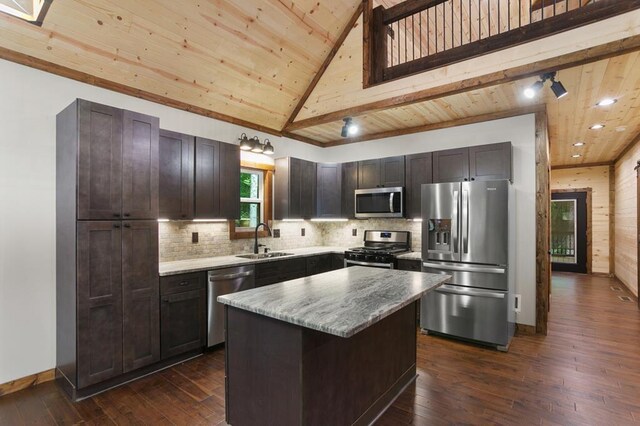 kitchen featuring tasteful backsplash, dark hardwood / wood-style flooring, a kitchen island, sink, and appliances with stainless steel finishes