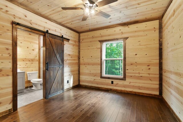 unfurnished room with a barn door, wooden ceiling, and hardwood / wood-style floors