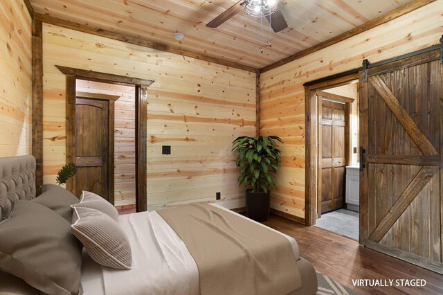 bedroom featuring a barn door, hardwood / wood-style flooring, and wood ceiling