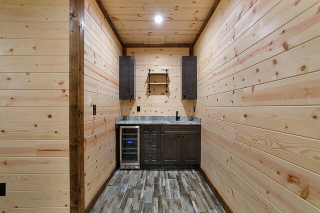 bathroom featuring wine cooler, wood ceiling, wooden walls, sink, and hardwood / wood-style flooring