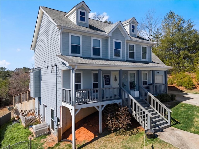 view of front of house featuring central air condition unit, covered porch, concrete driveway, and a shingled roof