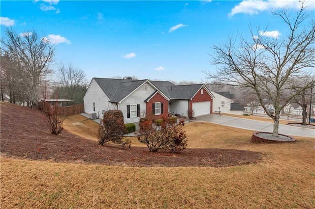 ranch-style house with concrete driveway, an attached garage, fence, and a front lawn