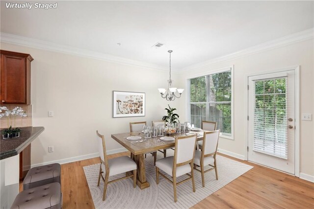 718 Surrey Park Pl SE, Smyrna, GA 30082 - dining area featuring crown molding, an inviting chandelier, and light hardwood / wood-style floors