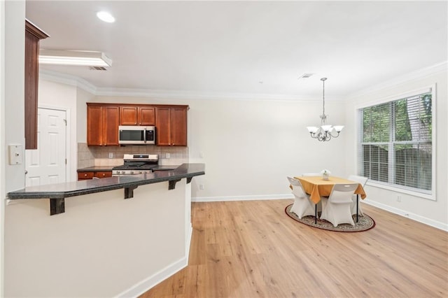 718 Surrey Park Pl SE, Smyrna, GA 30082 - kitchen with decorative backsplash, hanging light fixtures, a breakfast bar area, and stove