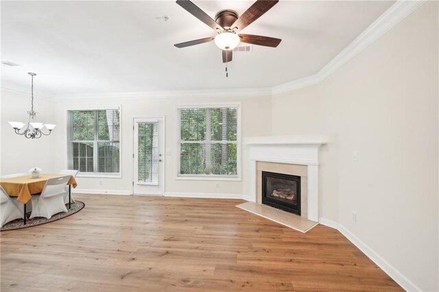 718 Surrey Park Pl SE, Smyrna, GA 30082 - unfurnished living room featuring ornamental molding, ceiling fan with notable chandelier, a fireplace, and light hardwood / wood-style floors