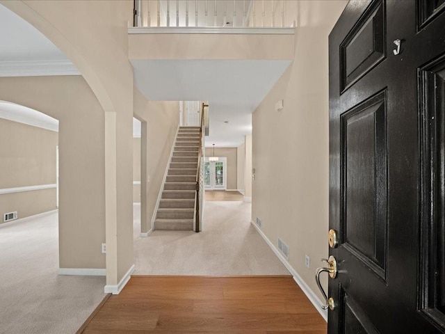 740 Orchard Ct, Atlanta, GA 30328 - entryway with carpet flooring, stairs, arched walkways, and wood finished floors