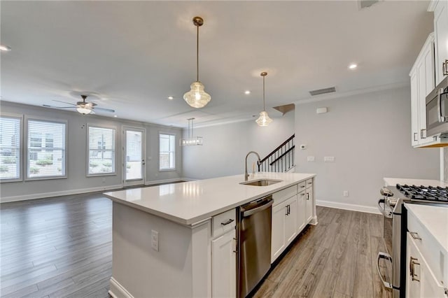 6270 Bracken Brown Dr, Alpharetta, GA 30004 - kitchen featuring stainless steel appliances, ceiling fan, wood finished floors, a center island with sink, and light countertops