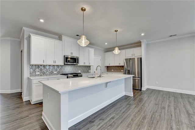 6270 Bracken Brown Dr, Alpharetta, GA 30004 - kitchen featuring appliances with stainless steel finishes, backsplash, crown molding, white cabinetry, and a kitchen island with sink