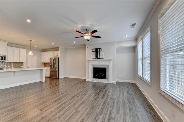 6270 Bracken Brown Dr, Alpharetta, GA 30004 - unfurnished living room with wood finished floors, ceiling fan, recessed lighting, a high end fireplace, and crown molding
