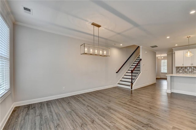 6270 Bracken Brown Dr, Alpharetta, GA 30004 - unfurnished living room featuring light wood-style flooring, stairway, ornamental molding, a chandelier, and recessed lighting