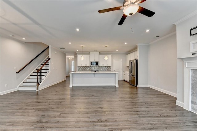 6270 Bracken Brown Dr, Alpharetta, GA 30004 - unfurnished living room with crown molding, recessed lighting, wood finished floors, stairs, and ceiling fan