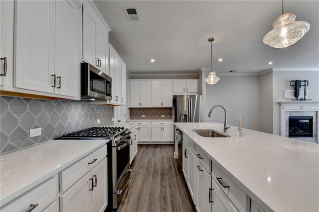 6270 Bracken Brown Dr, Alpharetta, GA 30004 - kitchen with appliances with stainless steel finishes, ornamental molding, dark wood-style flooring, white cabinets, and hanging light fixtures