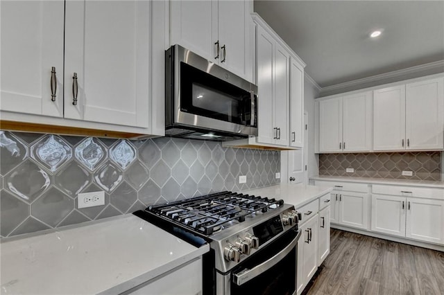 6270 Bracken Brown Dr, Alpharetta, GA 30004 - kitchen featuring appliances with stainless steel finishes, white cabinets, tasteful backsplash, crown molding, and light wood finished floors