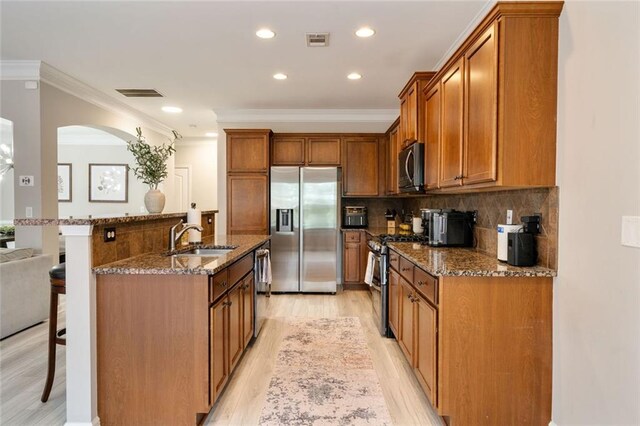 kitchen featuring a sink, appliances with stainless steel finishes, a breakfast bar area, and visible vents