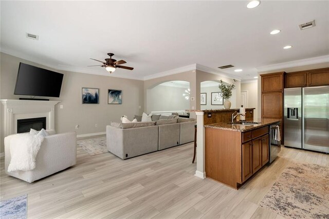 kitchen featuring visible vents, a sink, arched walkways, stainless steel fridge with ice dispenser, and a ceiling fan