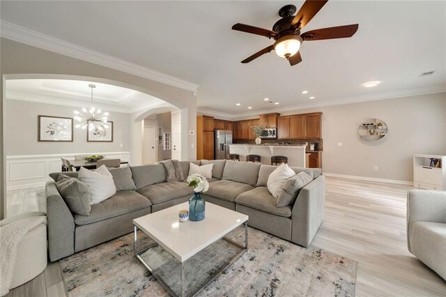 living room with visible vents, arched walkways, ceiling fan with notable chandelier, recessed lighting, and light wood-style flooring