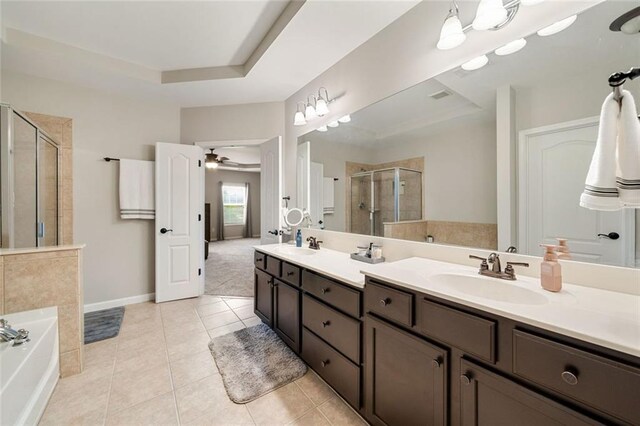 bathroom featuring a sink, double vanity, tile patterned floors, a bath, and a stall shower