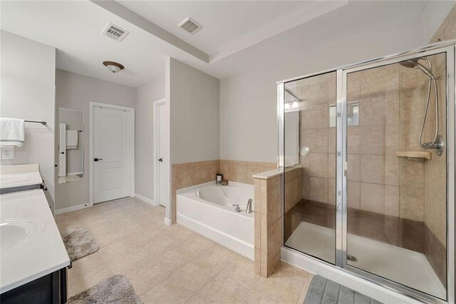 bathroom featuring double vanity, tile patterned floors, visible vents, a bath, and a stall shower