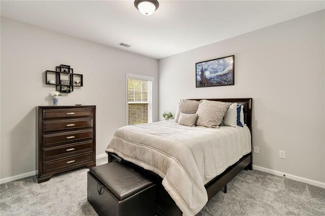 bedroom featuring visible vents, baseboards, and light colored carpet