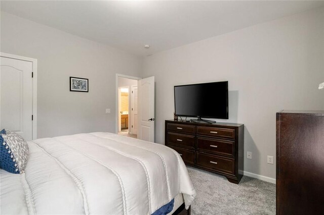 bedroom featuring light colored carpet and baseboards