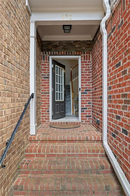 view of exterior entry with brick siding