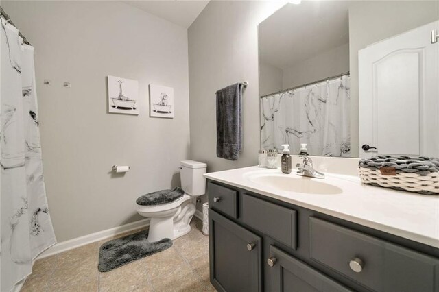 bathroom with toilet, baseboards, a shower with shower curtain, and vanity