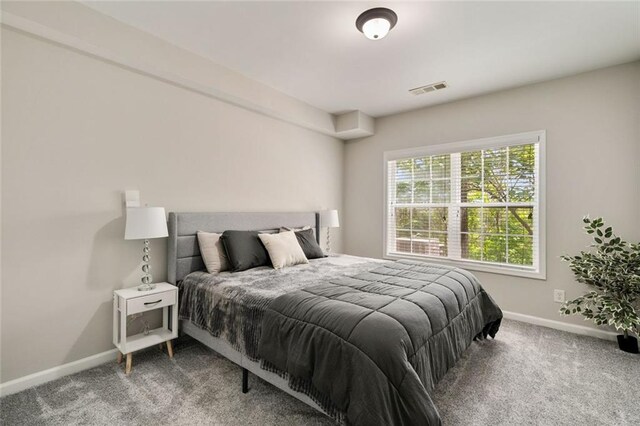 bedroom featuring baseboards, visible vents, and carpet