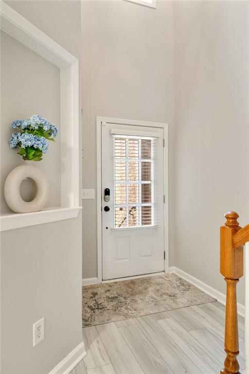 entryway with baseboards and wood finished floors