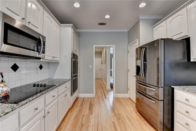 1901 Paper Birch Cv, Grayson, GA 30017 - kitchen with fridge with ice dispenser, black electric cooktop, stainless steel microwave, double oven, and light wood finished floors