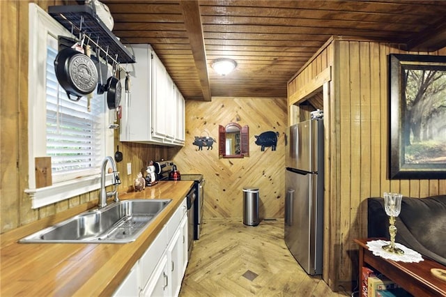 kitchen with a sink, wood ceiling, freestanding refrigerator, and wooden counters