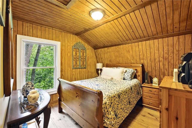 bedroom with light wood-style floors, wooden ceiling, wooden walls, and lofted ceiling